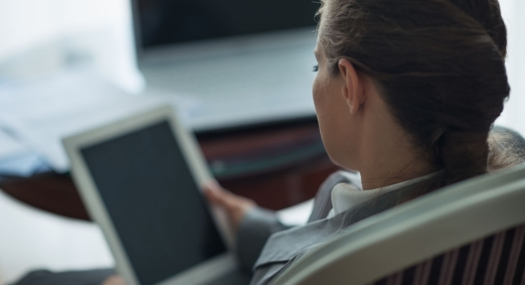 Business woman working with tablet PC. Rear view