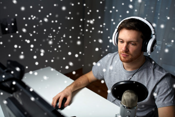 man in headset playing computer video game at home