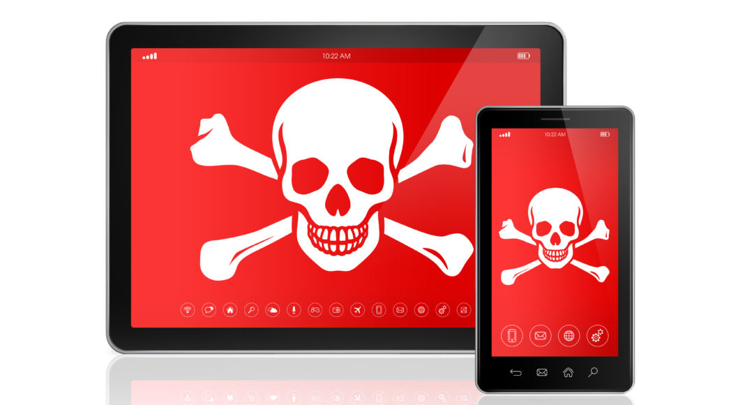 Digital tablet PC and smartphone with a pirate symbol on screen. Hacking concept