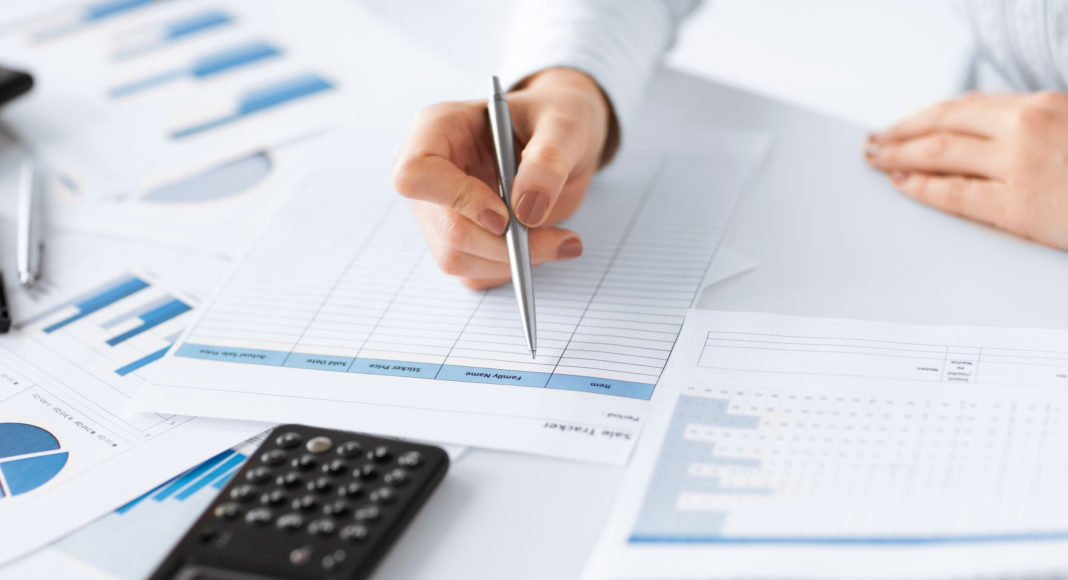 woman hand with calculator and papers