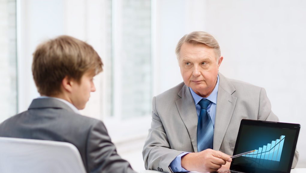 older man and young man with laptop computer