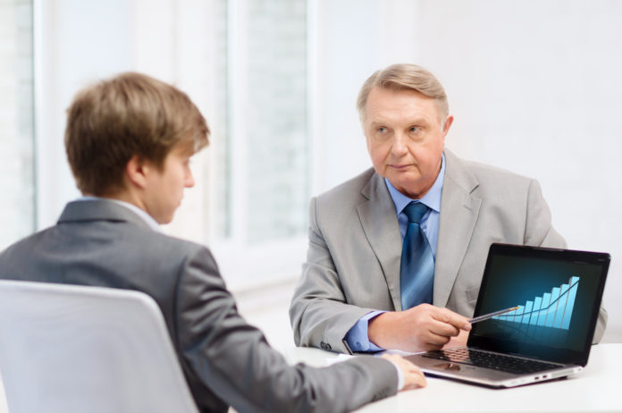 older man and young man with laptop computer