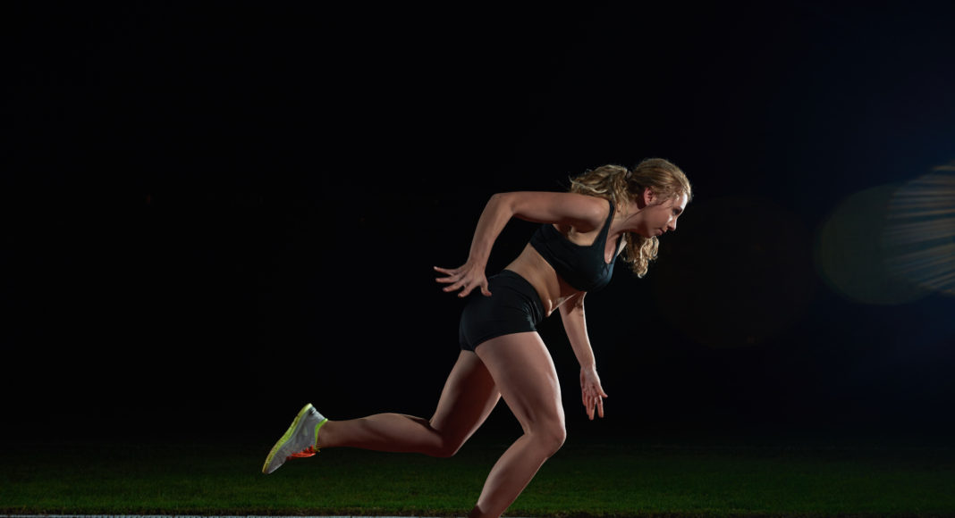 woman sprinter leaving starting blocks