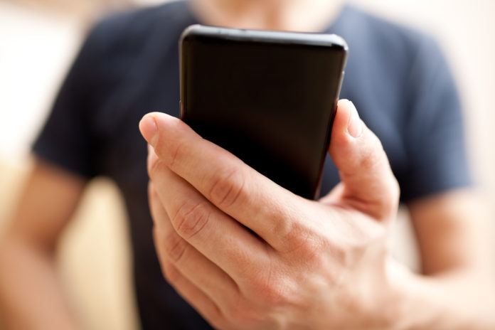 Close up of a man using mobile smart phone