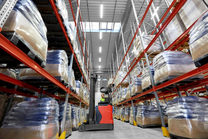 male loader operating forklift at warehouse