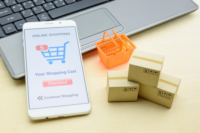 Online shopping / retail ecommerce and delivery service concept : Moblie with shopping app, a credit card on a laptop, depicts consumers purchase or order products from suppliers or digital stores.