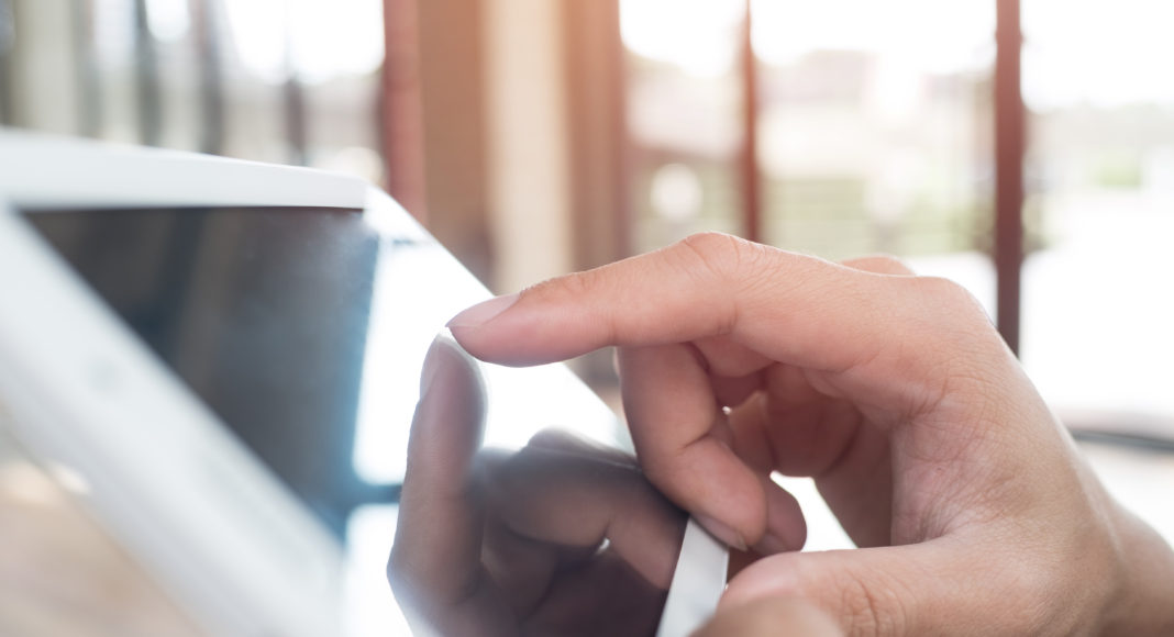 Man hand touching screen on modern digital tablet pc. Close-up i
