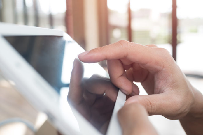 Man hand touching screen on modern digital tablet pc. Close-up i
