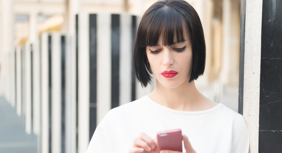 Fashion model with mobile device. Woman with red lips use on smartphone in paris, france. Woman with brunette hair hold mobile phone. Beauty girl with sexy look. New technology for modern life tiempo móvil